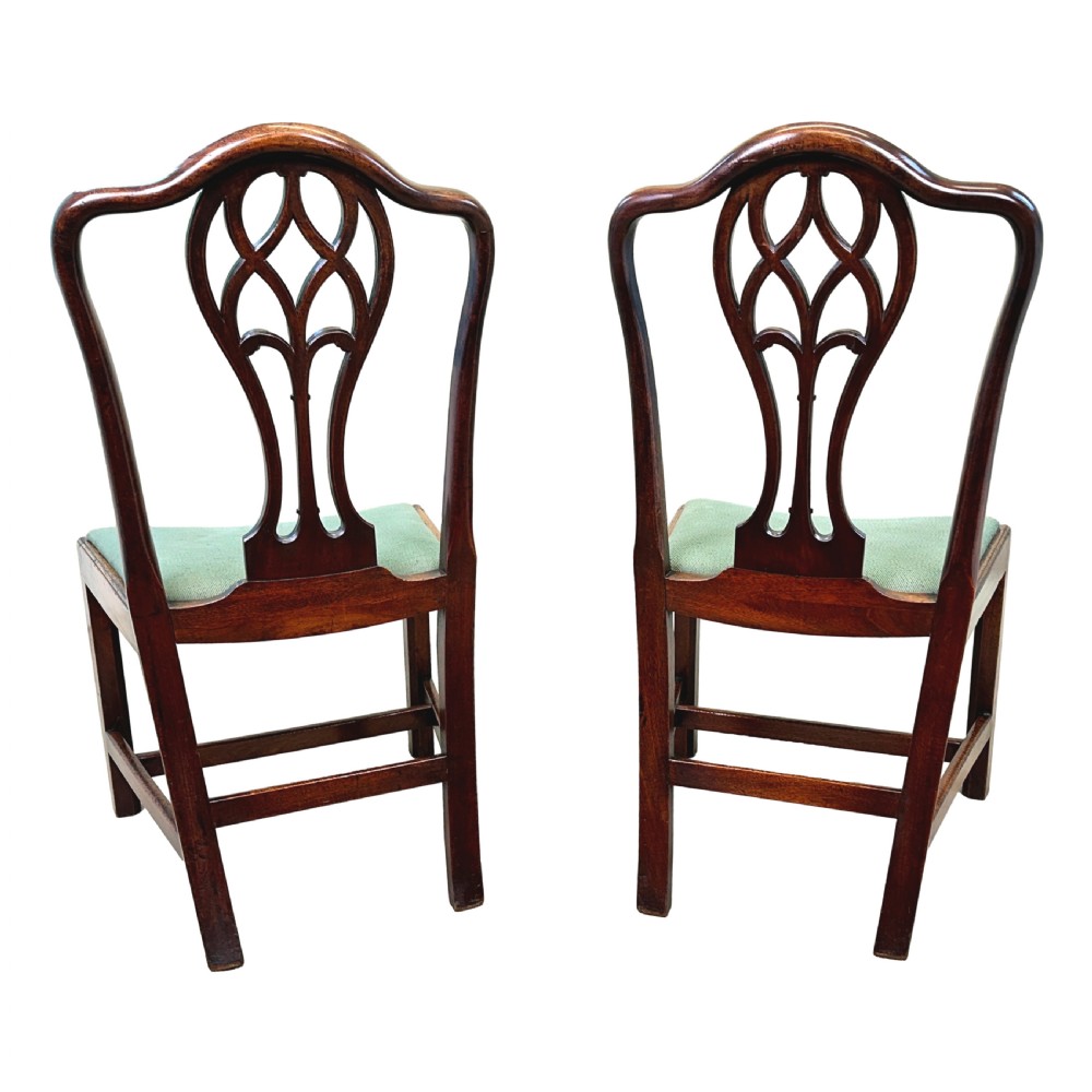 A pair of 18th-century Georgian mahogany side chairs featuring pierced back splats, serpentine top rails, and light green upholstered drop-in seats. View XI