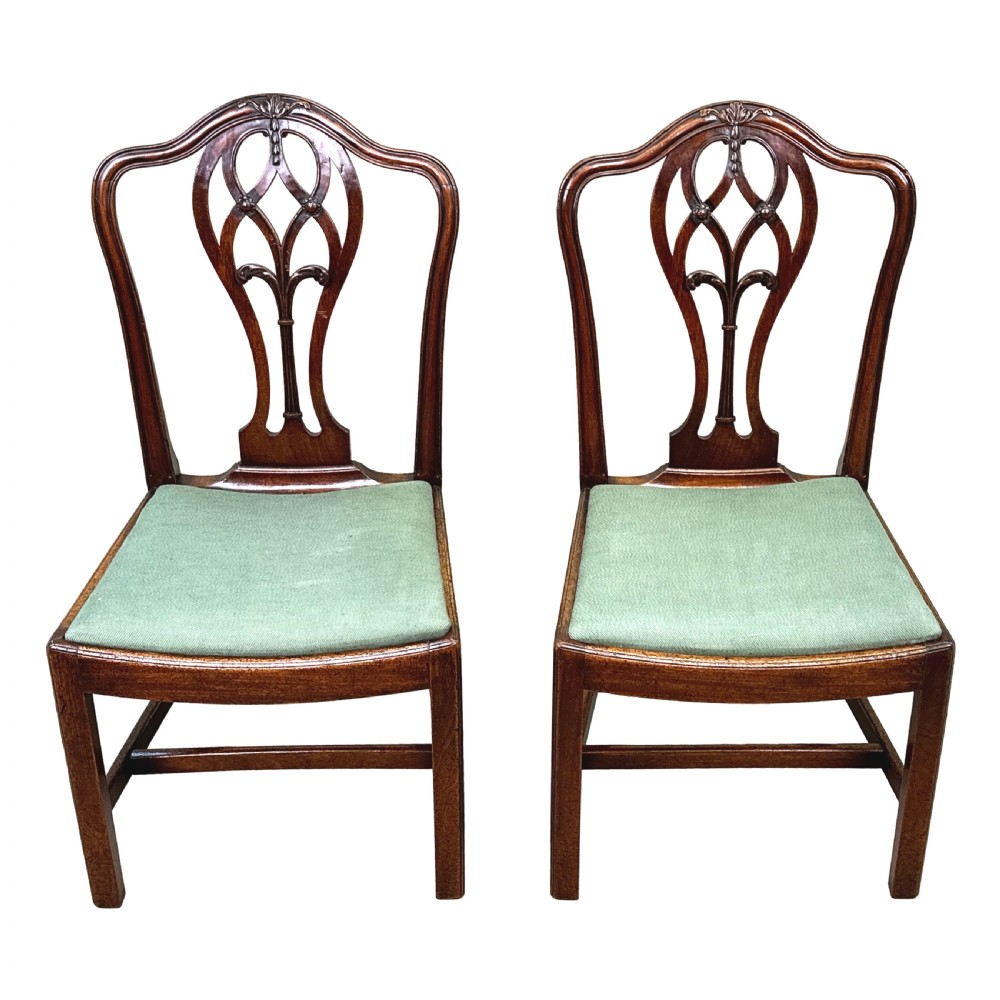 A pair of 18th-century Georgian mahogany side chairs featuring pierced back splats, serpentine top rails, and light green upholstered drop-in seats. View XII