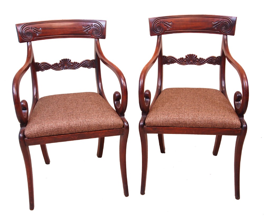 A set of eight Regency period mahogany dining chairs, including two carver armchairs and six side chairs, featuring carved bar backs and upholstered seats. View IV