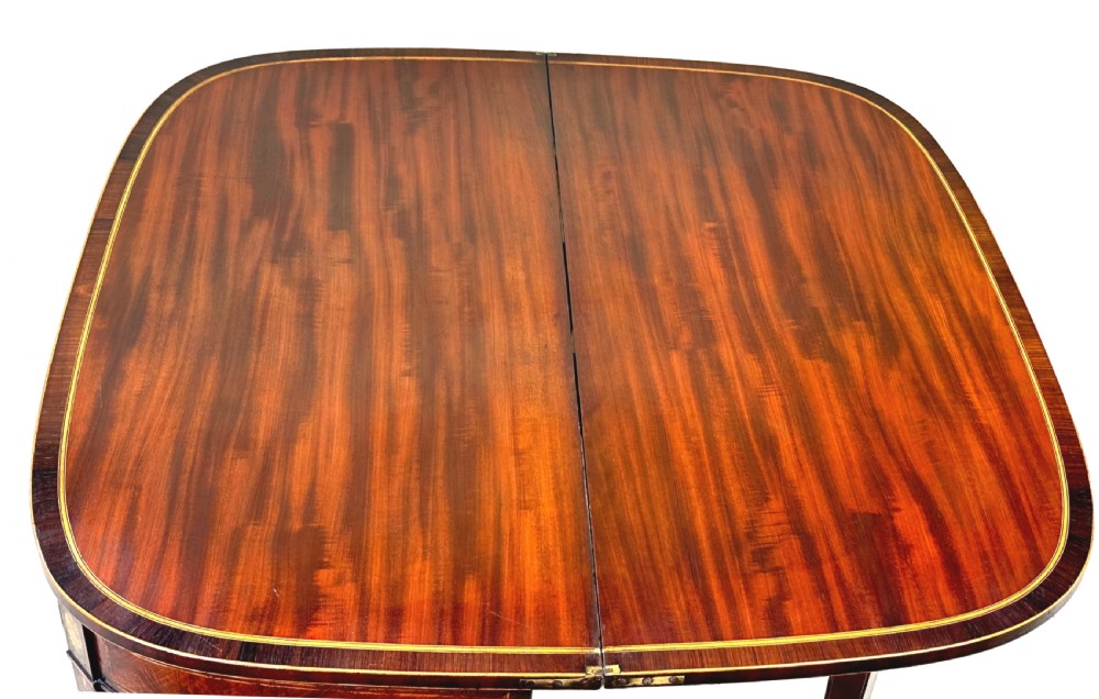 An eighteenth-century Georgian demilune mahogany tea table featuring decorative marquetry border, central brass mount, and tapered legs. View XI
