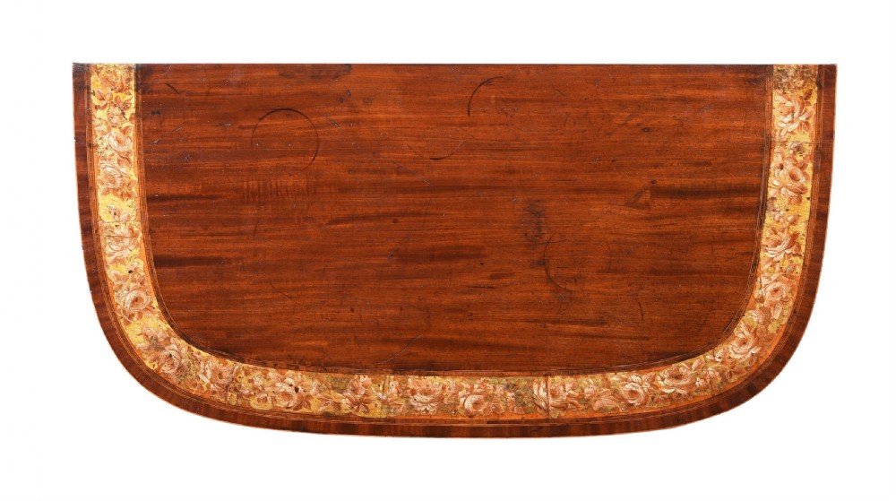 An eighteenth-century Georgian demilune mahogany tea table featuring decorative marquetry border, central brass mount, and tapered legs. View XVIII