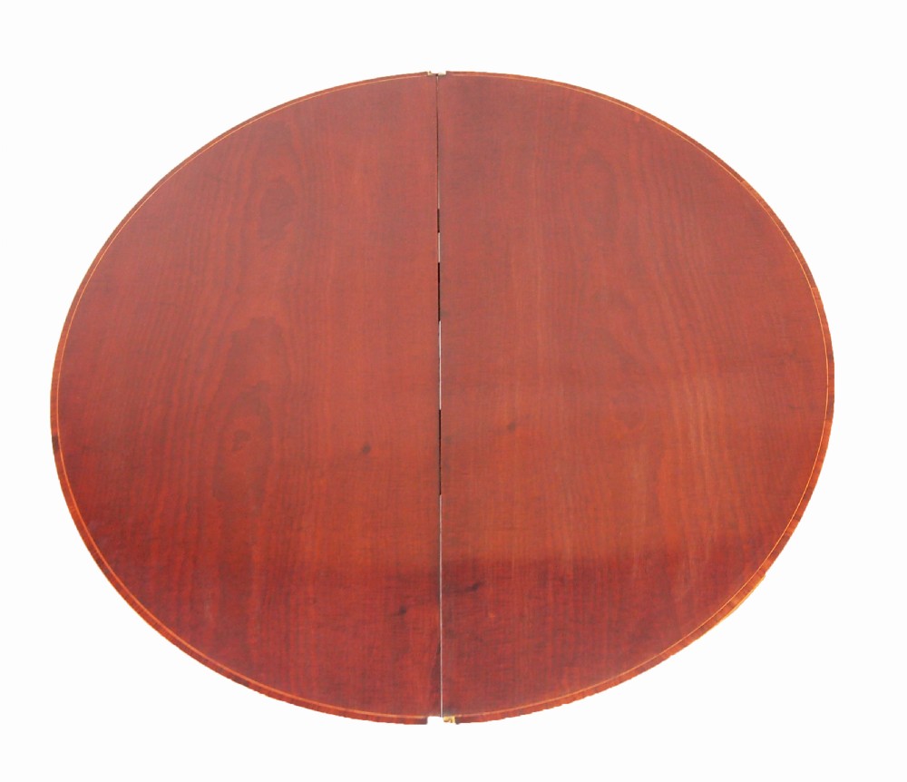 A Georgian mahogany demilune tea table featuring a semicircular fold-over top, inlaid apron, and four square tapered legs. View II