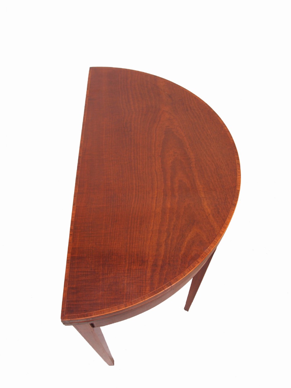 A Georgian mahogany demilune tea table featuring a semicircular fold-over top, inlaid apron, and four square tapered legs. View IV
