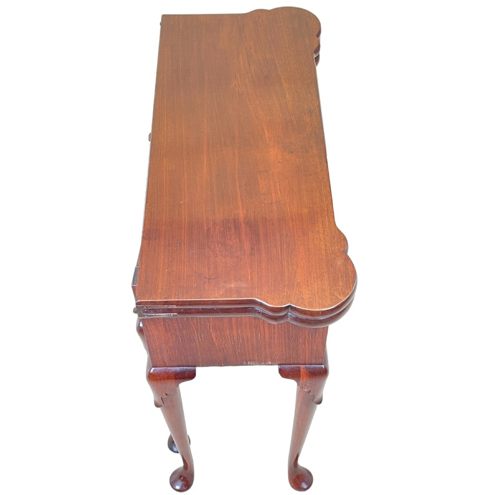 An 18th-century walnut tea table featuring a fold-over rectangular top with shaped corners, elevated on slender cabriole legs with pad feet. View III