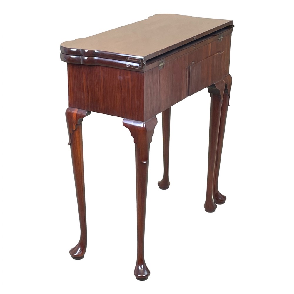 An 18th-century walnut tea table featuring a fold-over rectangular top with shaped corners, elevated on slender cabriole legs with pad feet. View V