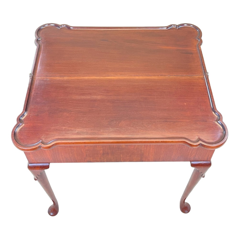 An 18th-century walnut tea table featuring a fold-over rectangular top with shaped corners, elevated on slender cabriole legs with pad feet. View VII