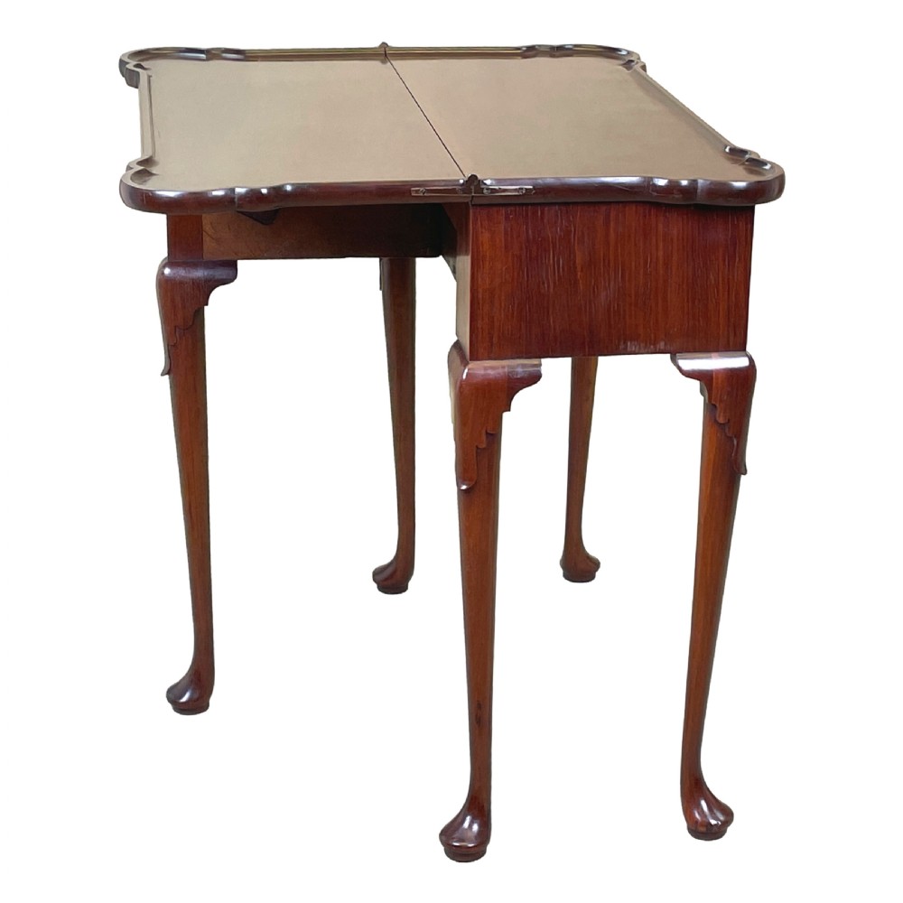 An 18th-century walnut tea table featuring a fold-over rectangular top with shaped corners, elevated on slender cabriole legs with pad feet. View XIII