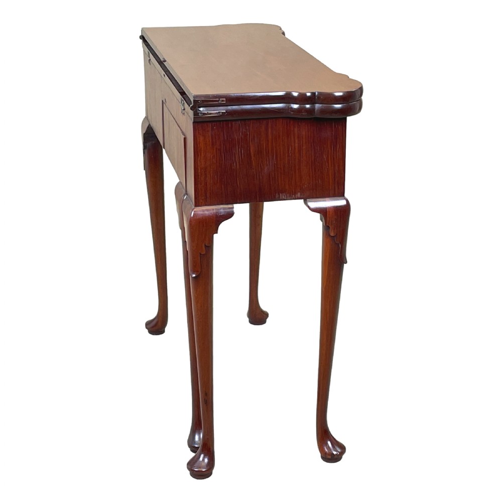 An 18th-century walnut tea table featuring a fold-over rectangular top with shaped corners, elevated on slender cabriole legs with pad feet. View XIV