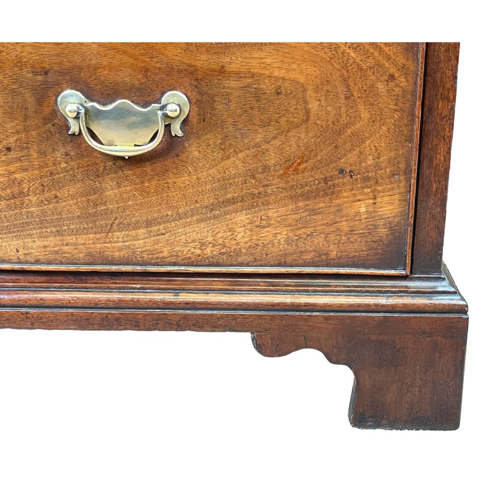 An 18th-century Georgian mahogany chest of drawers featuring four graduated drawers with brass swan-neck handles, escutcheons, and bracket feet. View VII