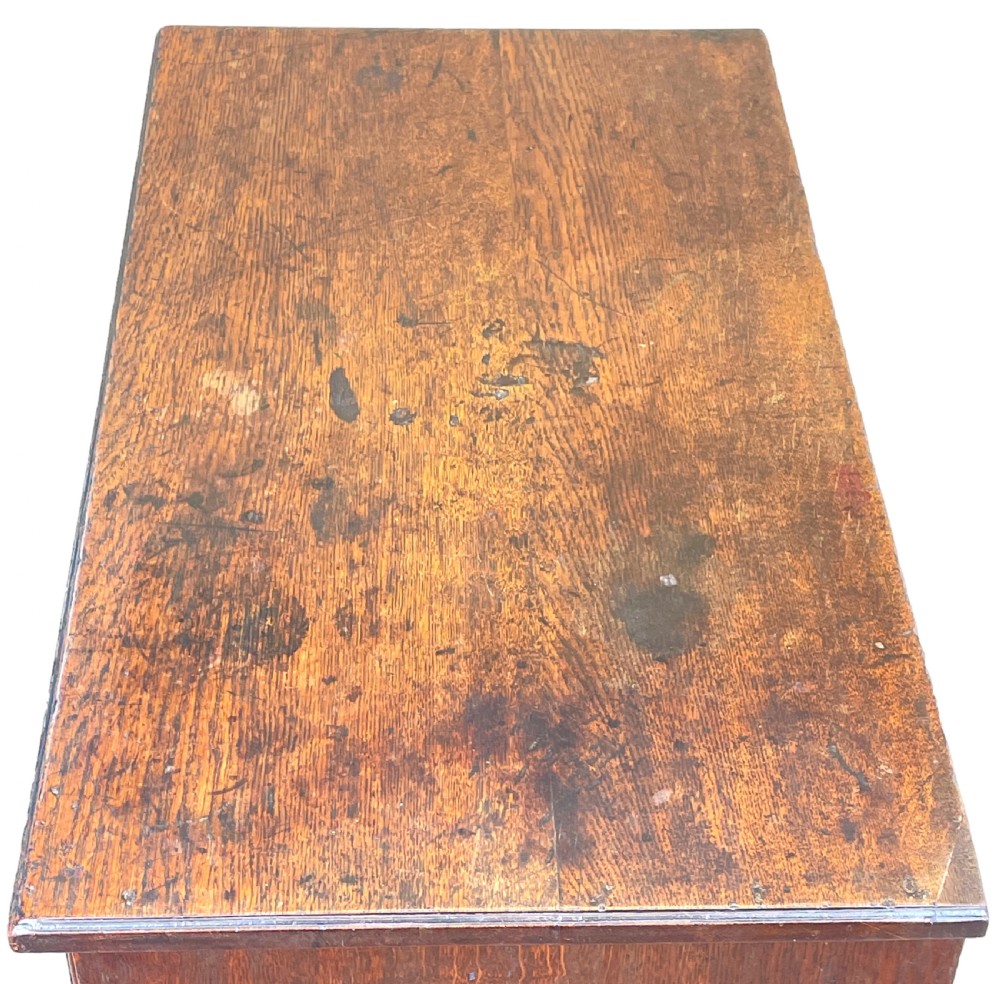 An eighteenth-century oak bachelors chest featuring four drawers with brass drop handles, escutcheons, a pull-out brushing slide, and bracket feet. View II