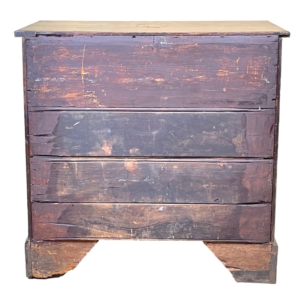 An eighteenth-century oak bachelors chest featuring four drawers with brass drop handles, escutcheons, a pull-out brushing slide, and bracket feet. View XI