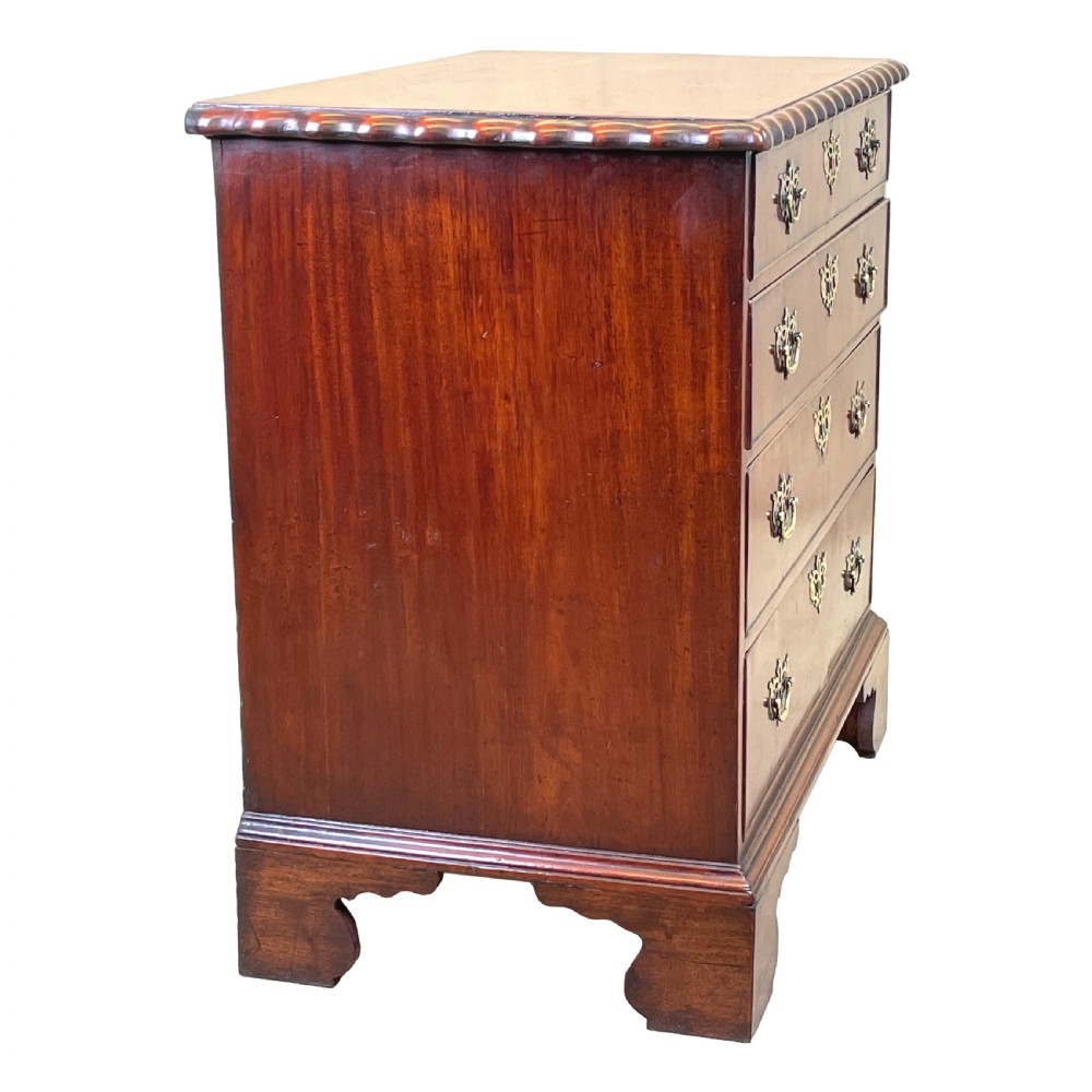 An 18th-century walnut chest of drawers featuring four graduated drawers with ornamental brass handles and escutcheons resting on shaped bracket feet. View II