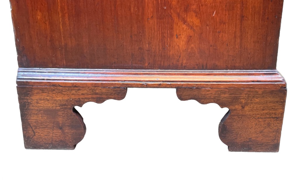 An 18th-century walnut chest of drawers featuring four graduated drawers with ornamental brass handles and escutcheons resting on shaped bracket feet. View X