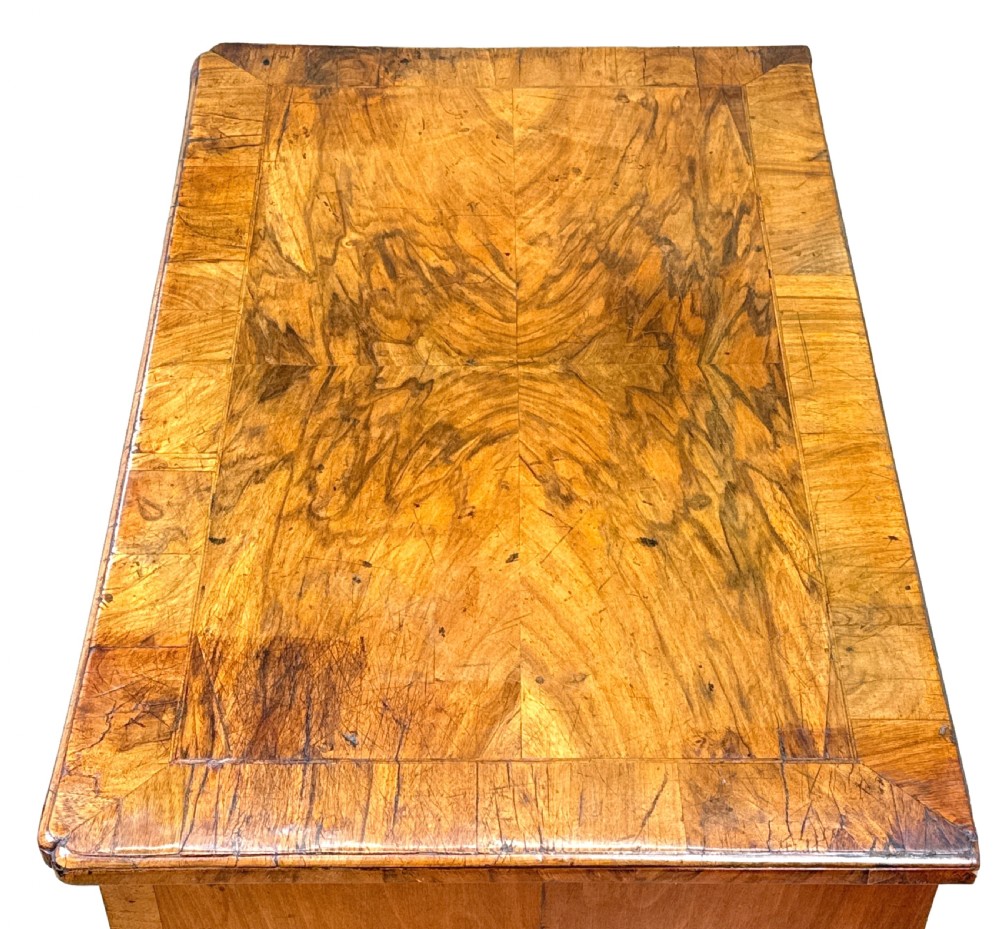 An 18th-century Georgian walnut kneehole desk featuring figured veneer drawer fronts, brass drop handles, and bracket feet. View III