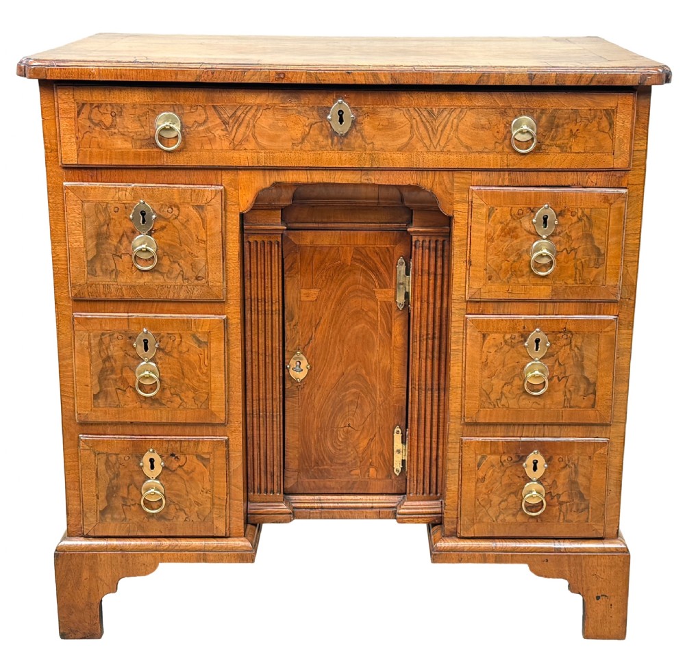 An 18th-century Georgian walnut kneehole desk featuring figured veneer drawer fronts, brass drop handles, and bracket feet. View XI