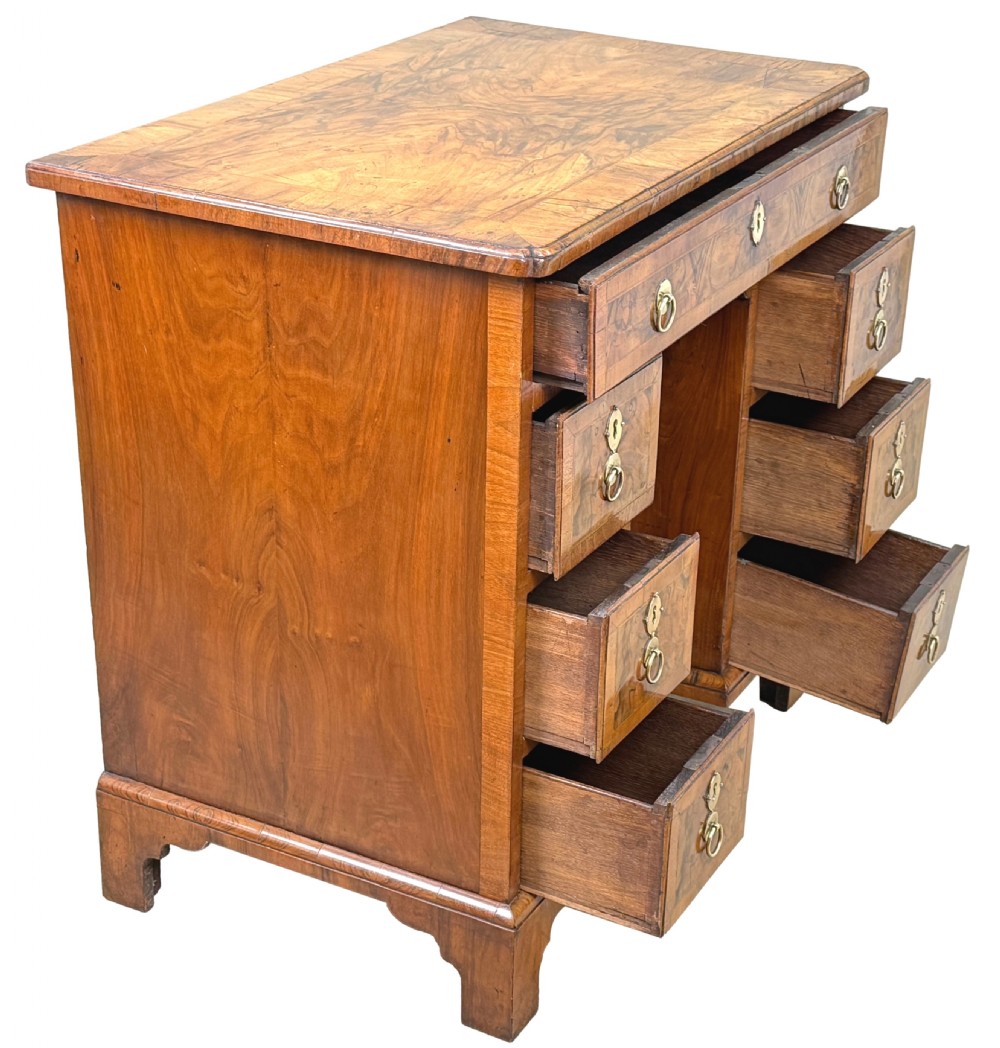 An 18th-century Georgian walnut kneehole desk featuring figured veneer drawer fronts, brass drop handles, and bracket feet. View XIV