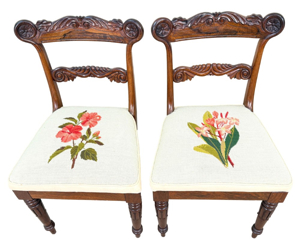 A set of ten Regency rosewood dining chairs featuring carved crest rails, scrolled mid-bars, turned front legs, and cream embroidered needlepoint seats. View III