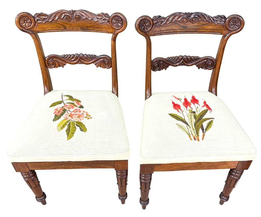 A set of ten Regency rosewood dining chairs featuring carved crest rails, scrolled mid-bars, turned front legs, and cream embroidered needlepoint seats. View IV