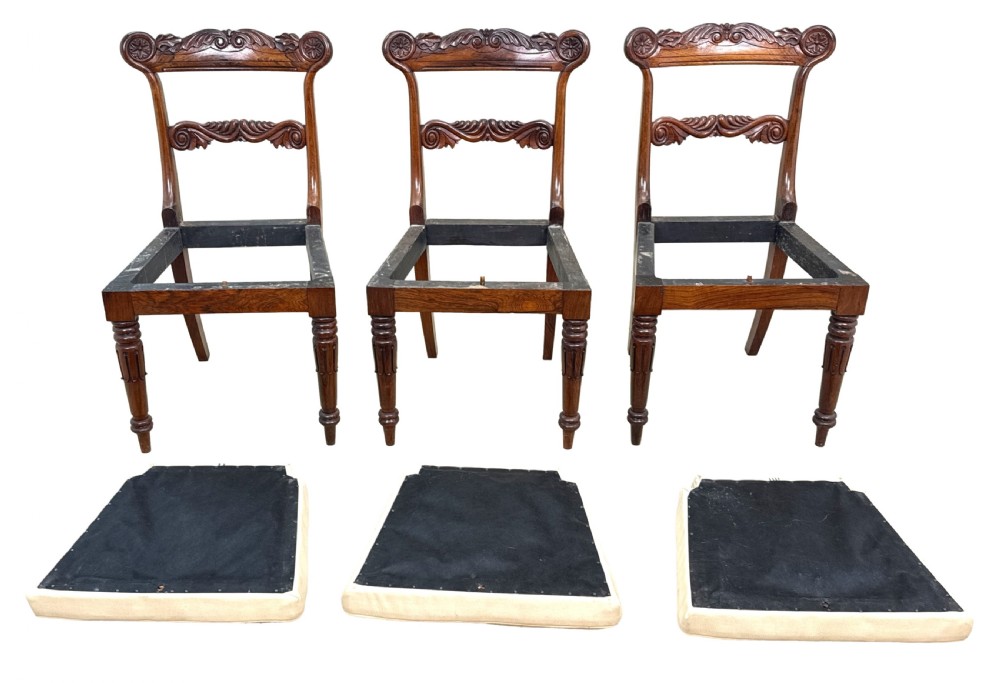 A set of ten Regency rosewood dining chairs featuring carved crest rails, scrolled mid-bars, turned front legs, and cream embroidered needlepoint seats. View XX