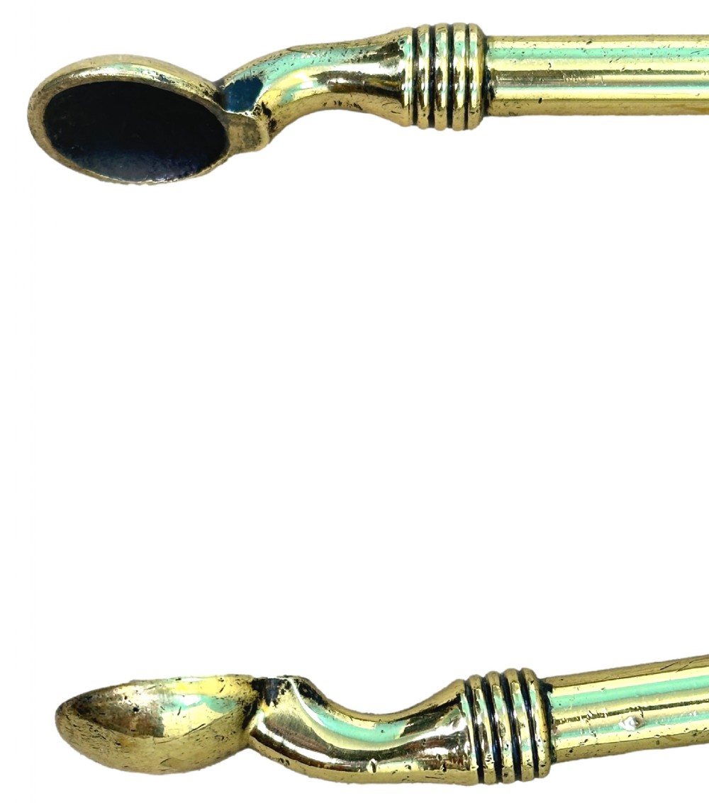A three-piece set of 19th-century brass fire tools comprising a pierced shovel, tongs, and a steel-tipped poker with turned finial handles. View V