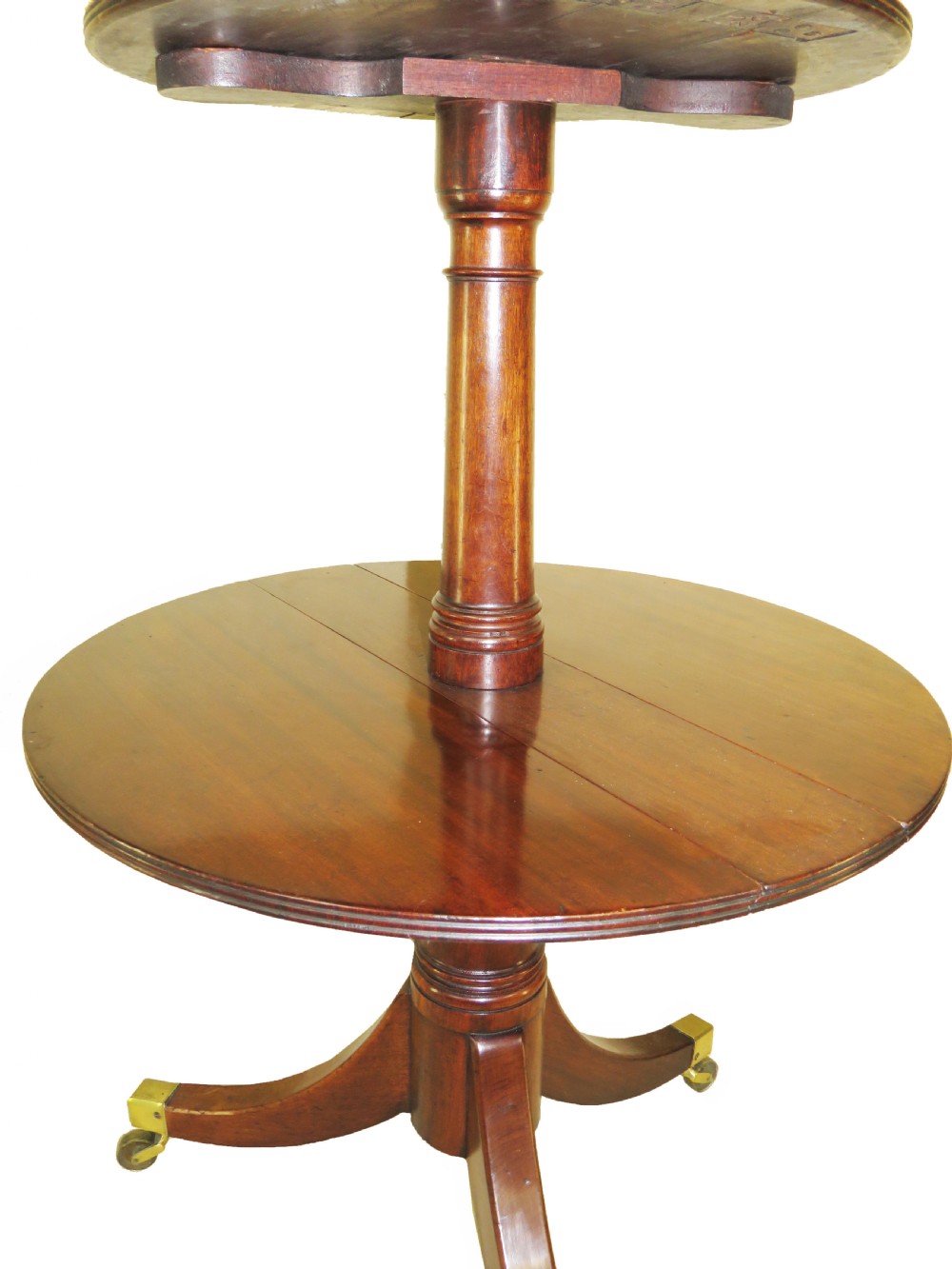 A late eighteenth-century mahogany dumbwaiter featuring two circular folding tiers supported by a central turned column and tripod legs with brass castors. View IV