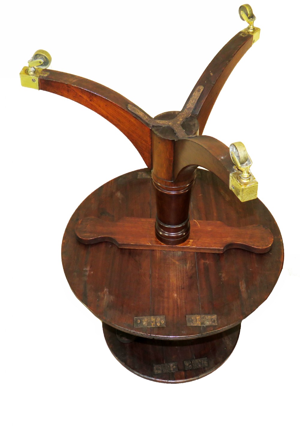 A late eighteenth-century mahogany dumbwaiter featuring two circular folding tiers supported by a central turned column and tripod legs with brass castors. View V