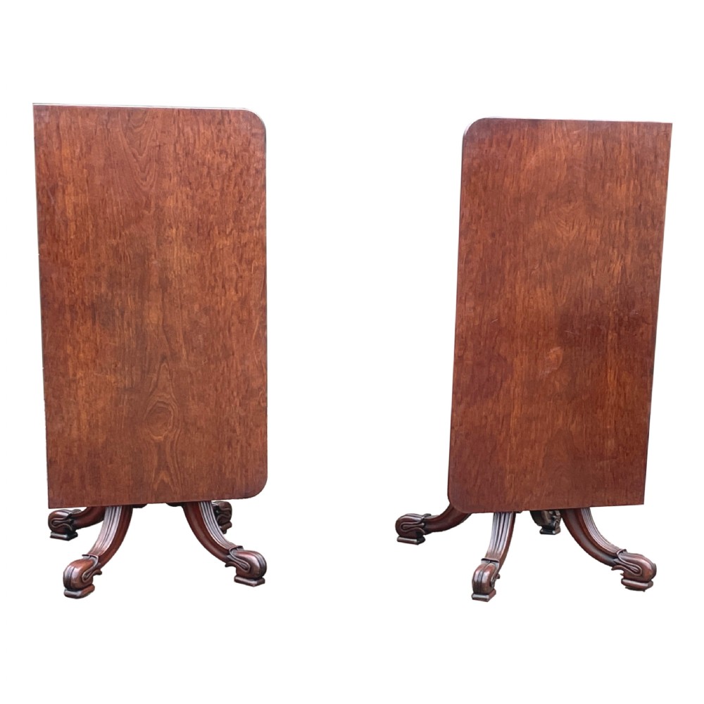 A Regency mahogany twin pillar dining table with an extending centre leaf and carved pedestal supports on brass castors. View IX
