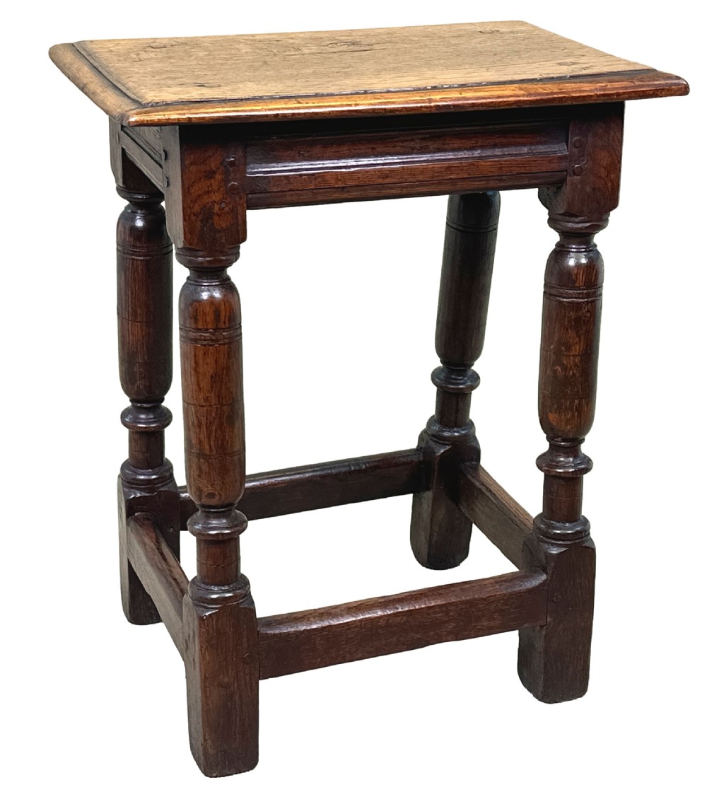 A 17th century rectangular dark oak joint stool featuring turned legs, pegged mortise and tenon joinery, and perimeter stretchers. View VIII