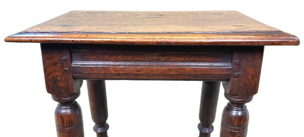 A 17th century rectangular dark oak joint stool featuring turned legs, pegged mortise and tenon joinery, and perimeter stretchers. View XI