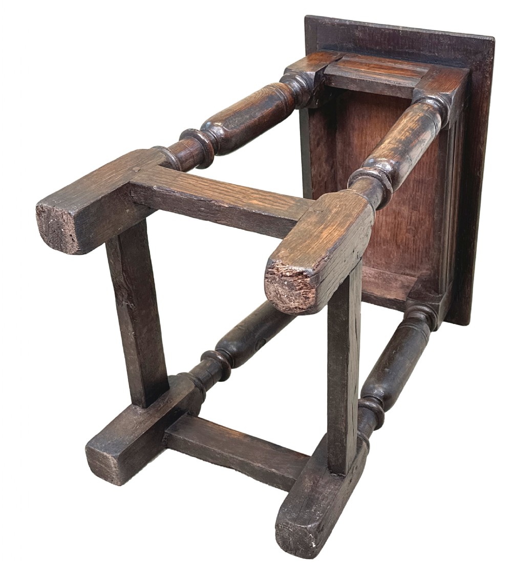 A 17th century rectangular dark oak joint stool featuring turned legs, pegged mortise and tenon joinery, and perimeter stretchers. View XII