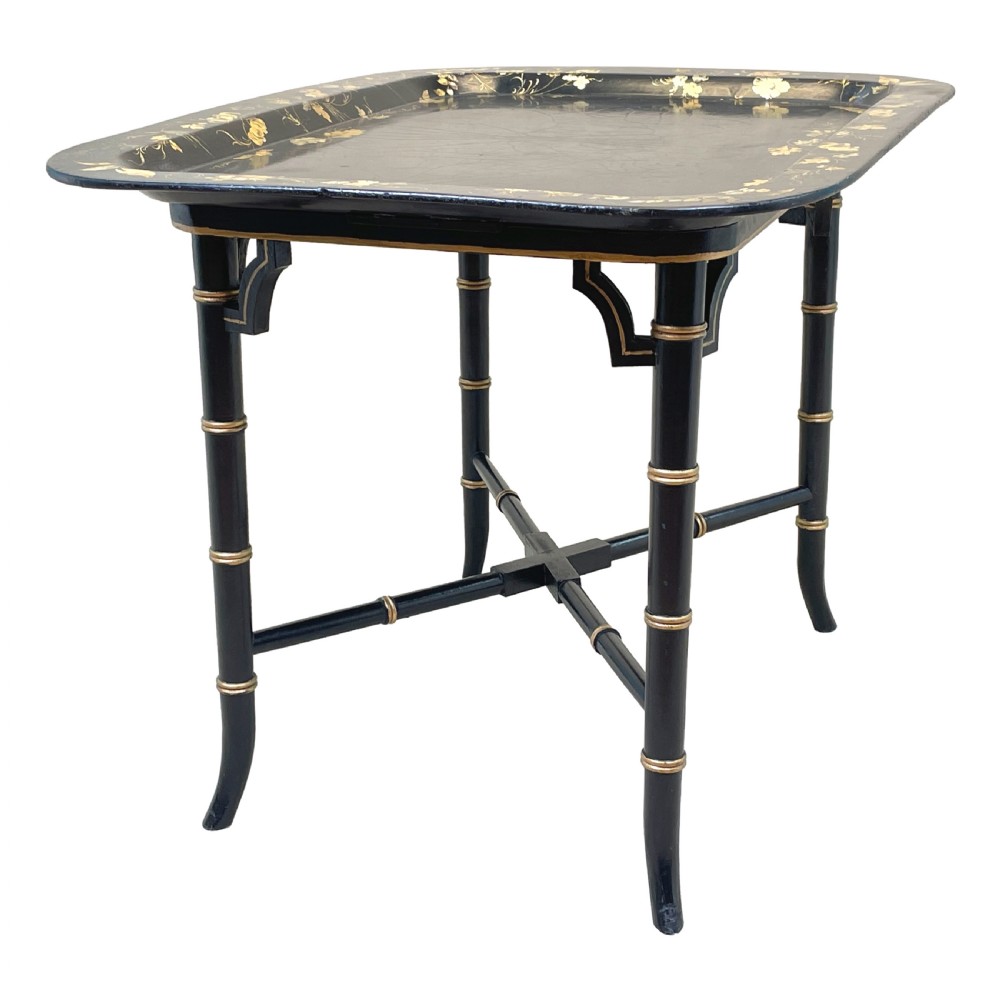 A black lacquered rectangular papier-mache tray table with gilded floral decorations set on ebonised faux bamboo legs. View II