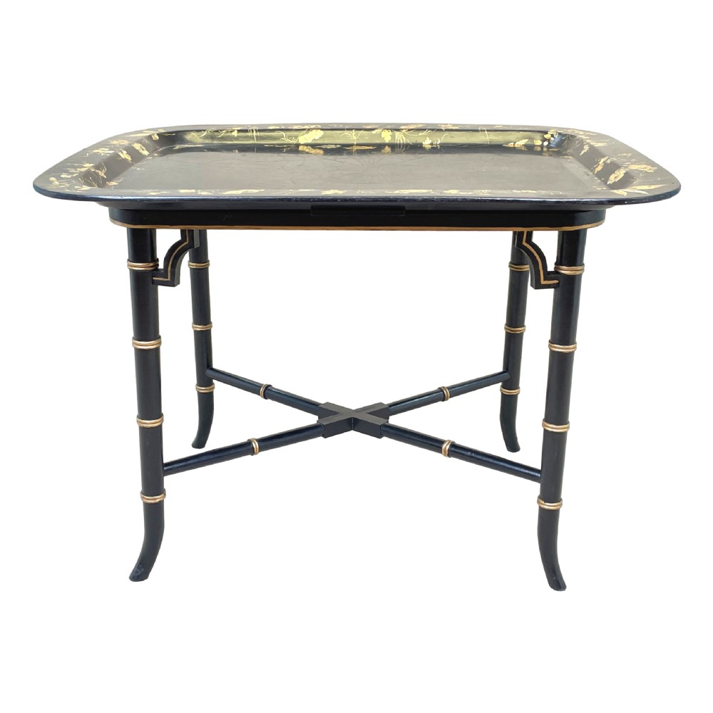 A black lacquered rectangular papier-mache tray table with gilded floral decorations set on ebonised faux bamboo legs. View VI