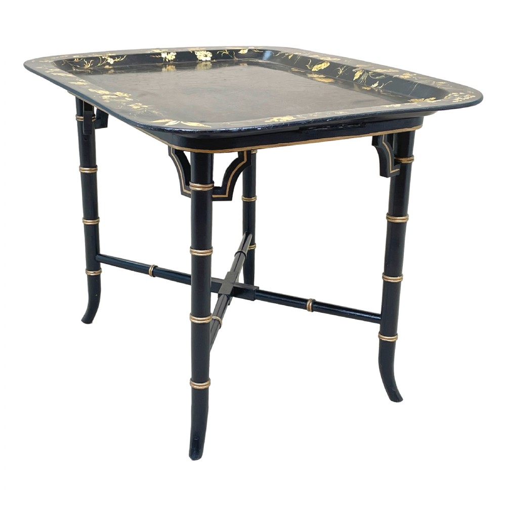 A black lacquered rectangular papier-mache tray table with gilded floral decorations set on ebonised faux bamboo legs. View VIII