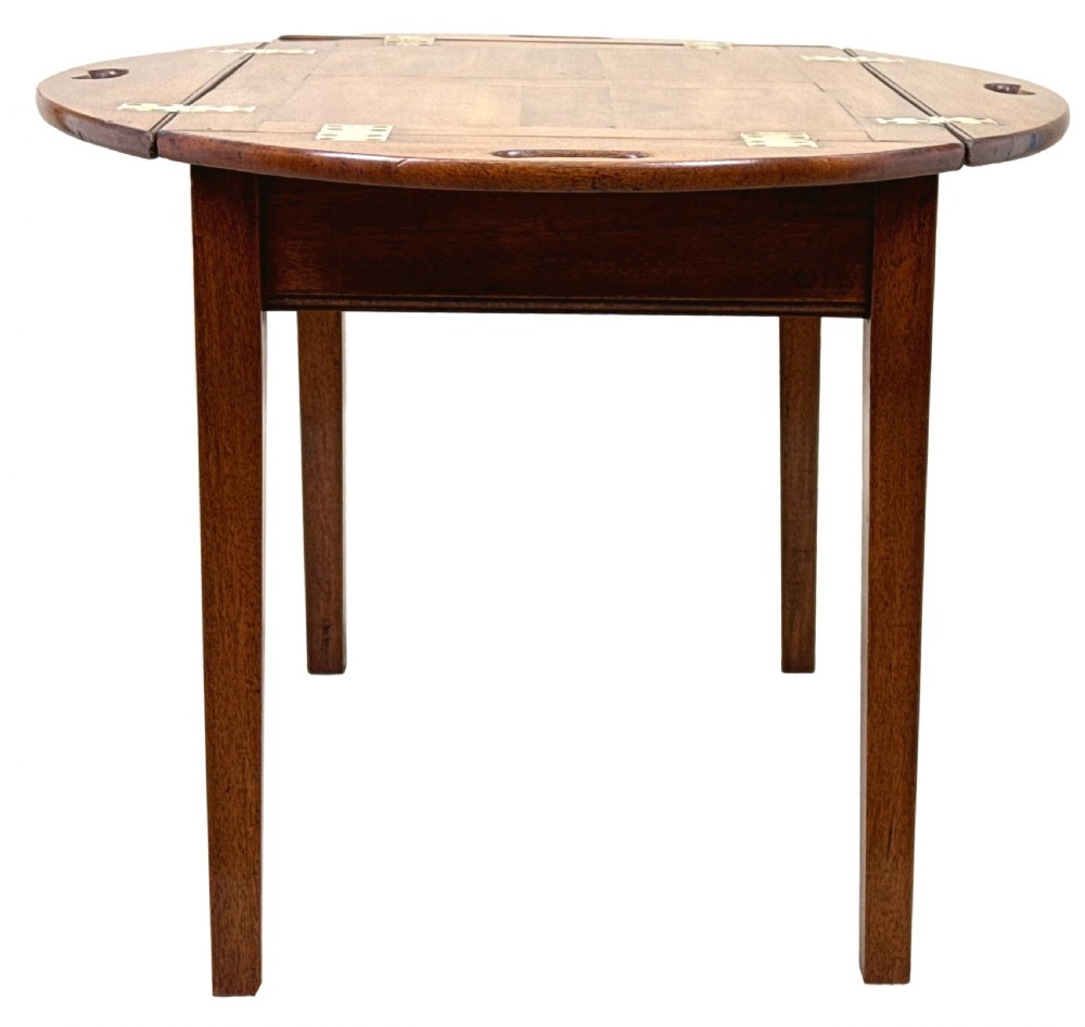 A Georgian mahogany oval butler tray table featuring brass-hinged drop sides with cut-out hand-grips resting on four square legs. View III