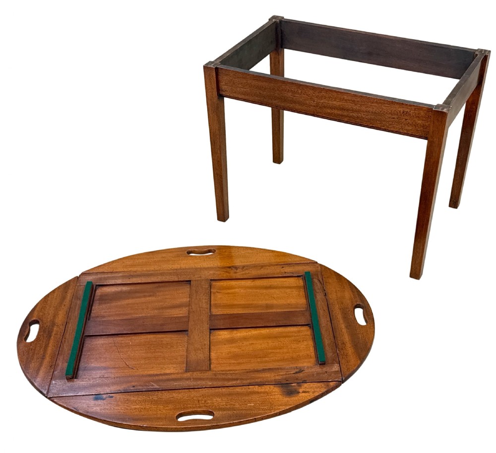 A Georgian mahogany oval butler tray table featuring brass-hinged drop sides with cut-out hand-grips resting on four square legs. View IX