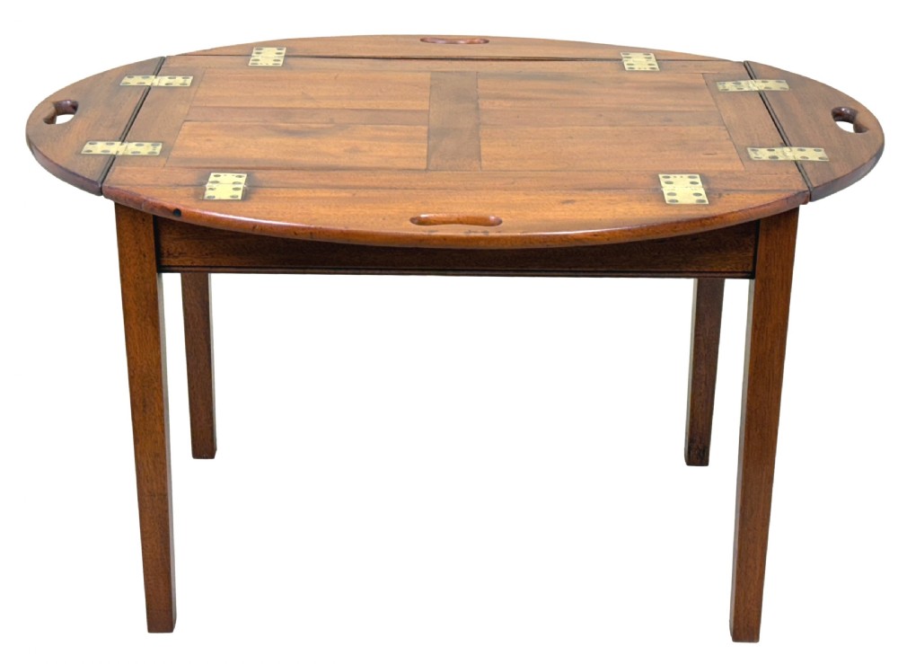 A Georgian mahogany oval butler tray table featuring brass-hinged drop sides with cut-out hand-grips resting on four square legs. View XI