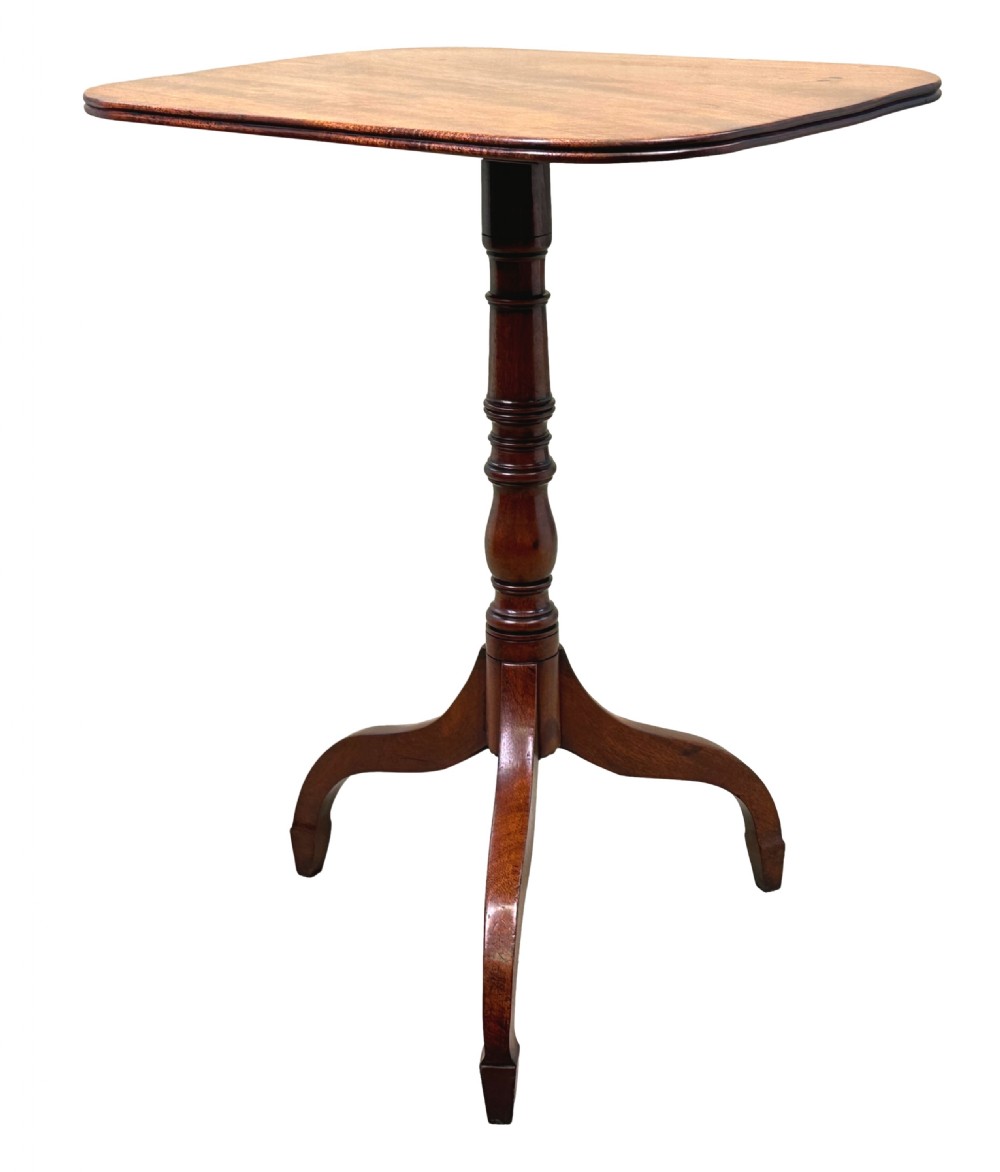 A Regency mahogany tilt-top wine table featuring a rectangular surface with rounded corners, supported by a turned central pedestal and a tripod base.