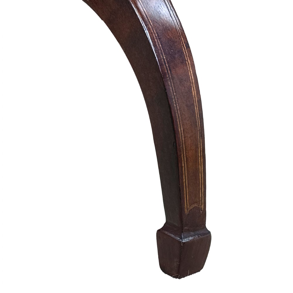 An antique Georgian circular mahogany wine table displayed with its top tilted upwards, supported by a turned pedestal column and a tripod base with three curved legs. View IV