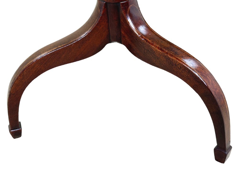 An antique Georgian circular mahogany wine table displayed with its top tilted upwards, supported by a turned pedestal column and a tripod base with three curved legs. View XI