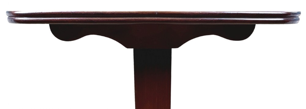 A small Georgian dark mahogany library table featuring a rectangular top, a stretchered trestle base, down-swept sabre legs, and brass castors. View IV