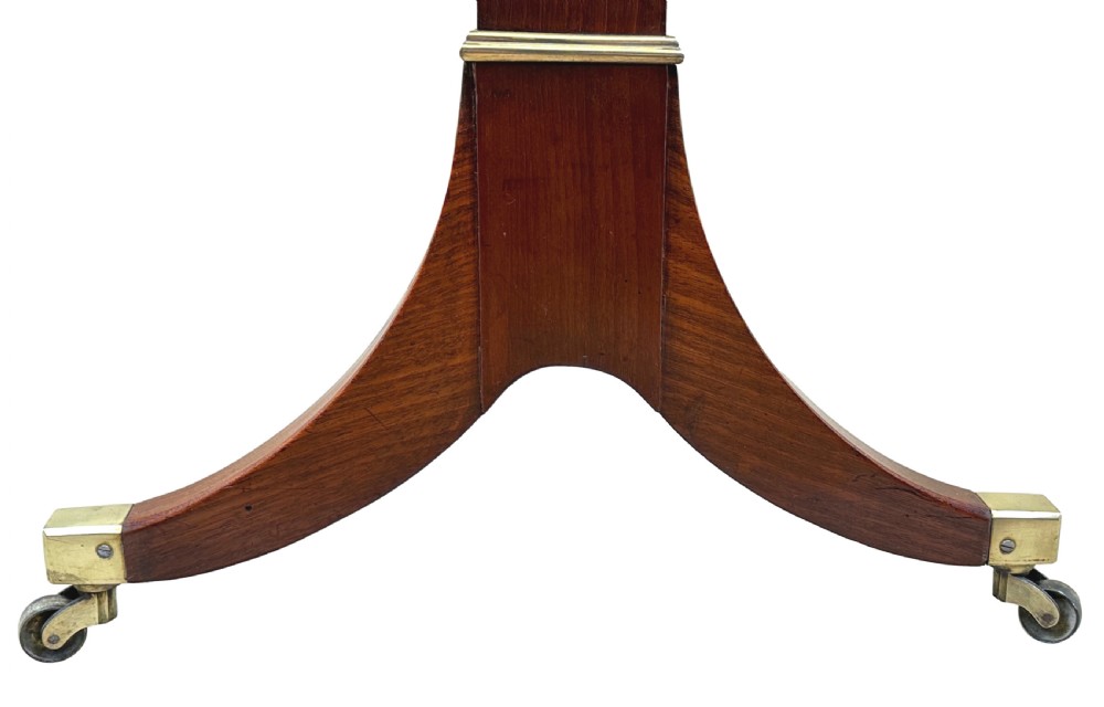 A small Georgian dark mahogany library table featuring a rectangular top, a stretchered trestle base, down-swept sabre legs, and brass castors. View VII
