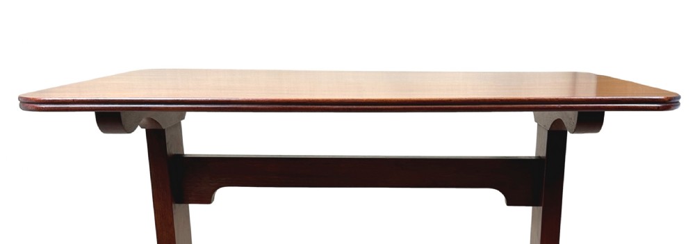A small Georgian dark mahogany library table featuring a rectangular top, a stretchered trestle base, down-swept sabre legs, and brass castors. View VIII