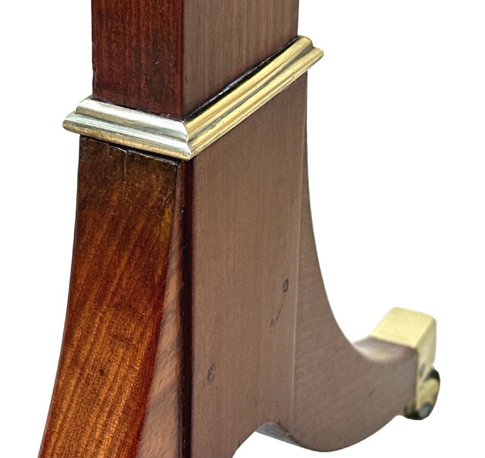 A small Georgian dark mahogany library table featuring a rectangular top, a stretchered trestle base, down-swept sabre legs, and brass castors. View IX
