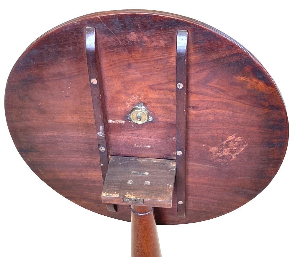 A circular Georgian mahogany wine table with a turned central column resting on a tripod base with reeded legs. View XI