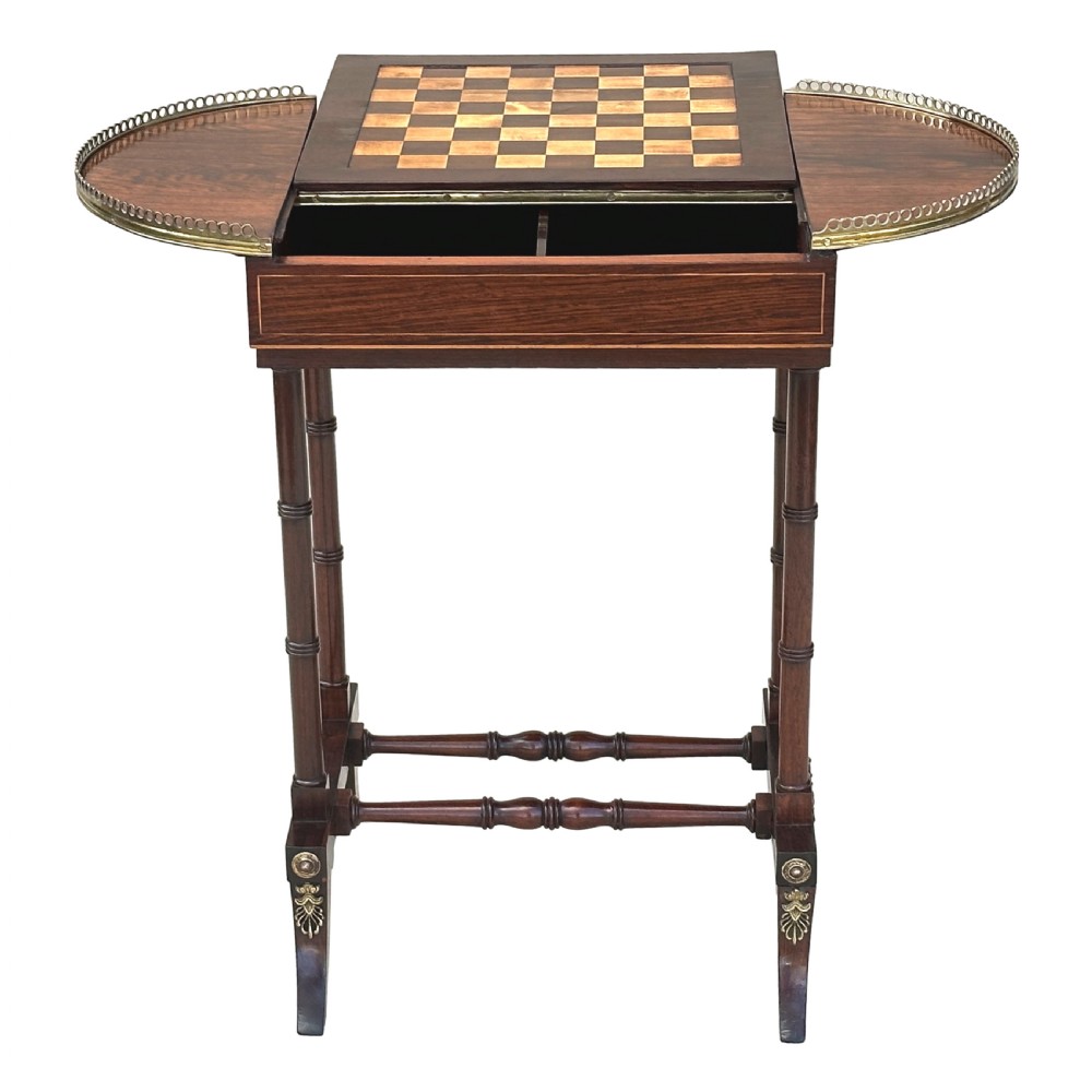 A dark rosewood Regency games table featuring slender ring-turned legs, a pierced brass gallery railing on top, and brass mounts on splayed feet. View II