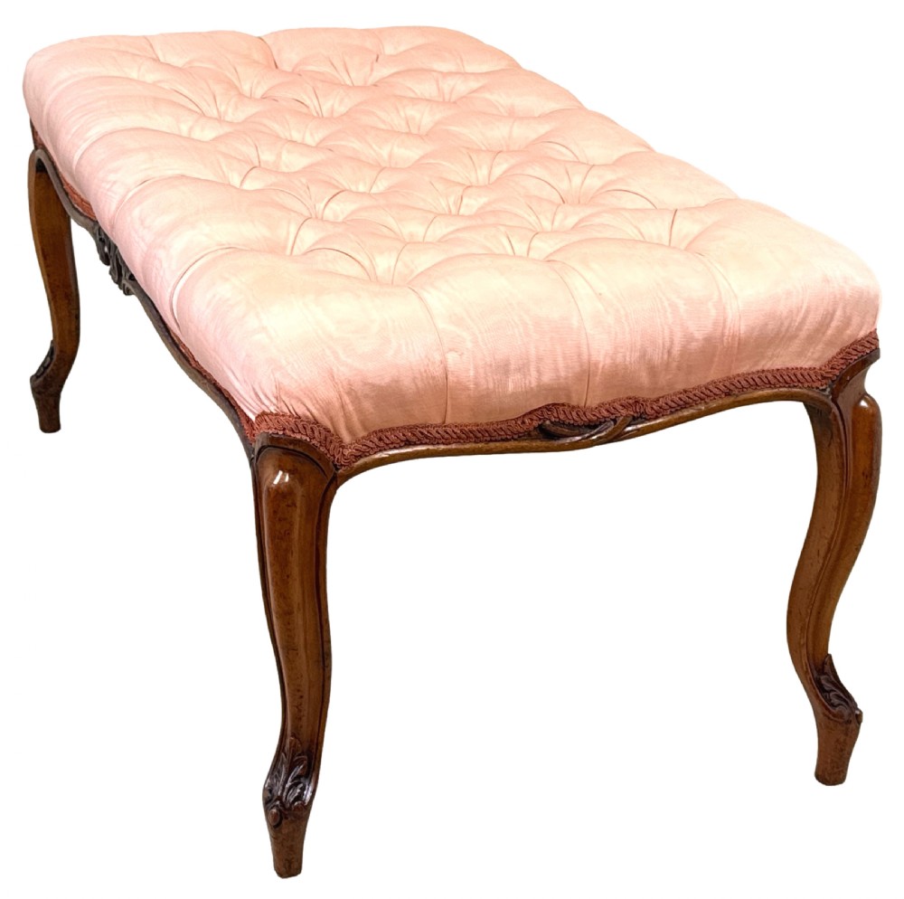 A rectangular Victorian walnut salon stool featuring a button-tufted pink fabric top, carved serpentine apron, and four cabriole legs. View II