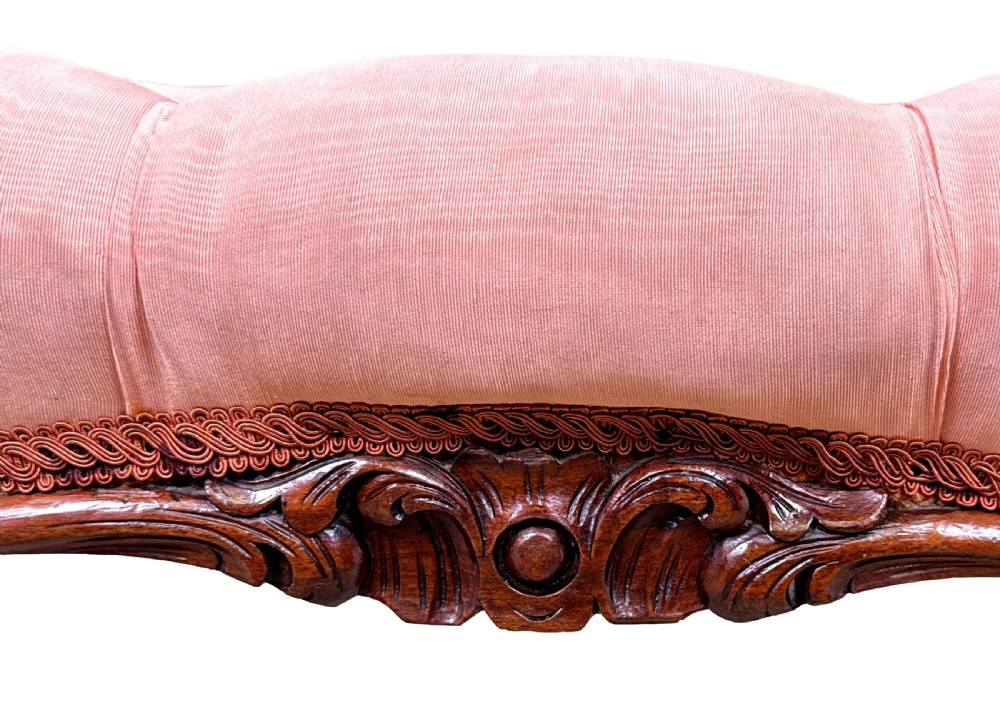 A rectangular Victorian walnut salon stool featuring a button-tufted pink fabric top, carved serpentine apron, and four cabriole legs. View IV