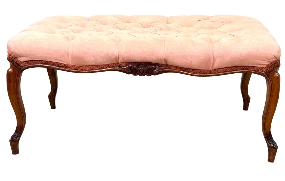 A rectangular Victorian walnut salon stool featuring a button-tufted pink fabric top, carved serpentine apron, and four cabriole legs. View XI