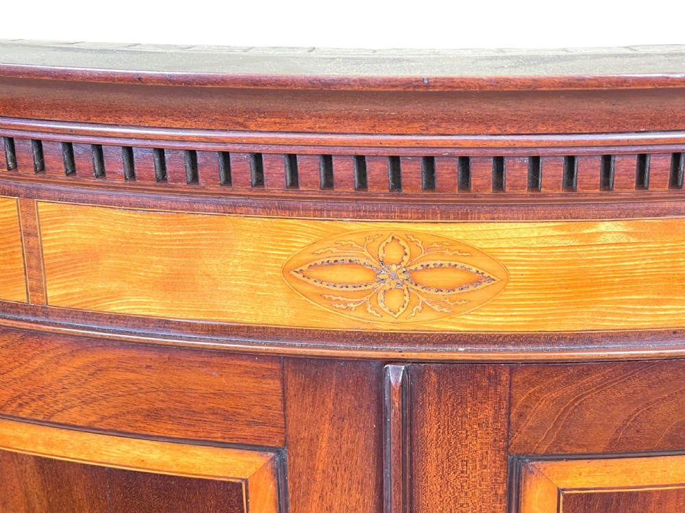 A Georgian bowfront mahogany corner cupboard featuring flame mahogany door panels, classical marquetry inlay, and double doors. View III
