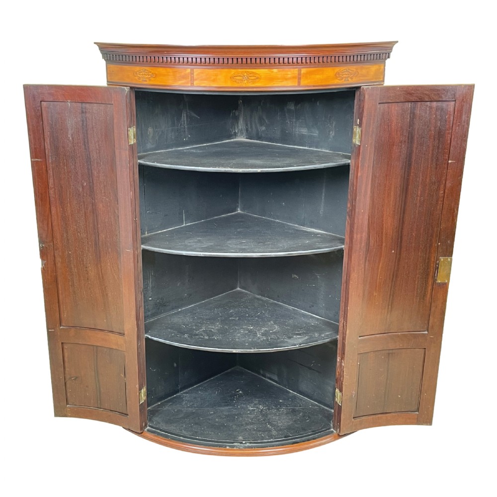 A Georgian bowfront mahogany corner cupboard featuring flame mahogany door panels, classical marquetry inlay, and double doors. View VIII